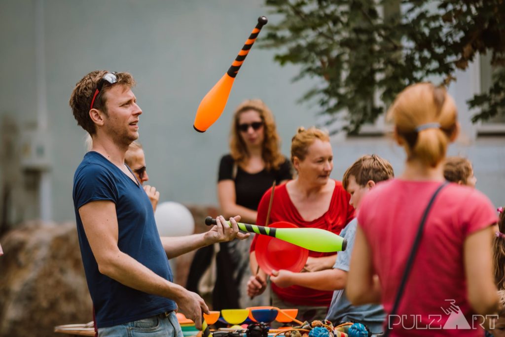 Zsonglőr játszóházban artista zsonglőr buzogányokat dobál